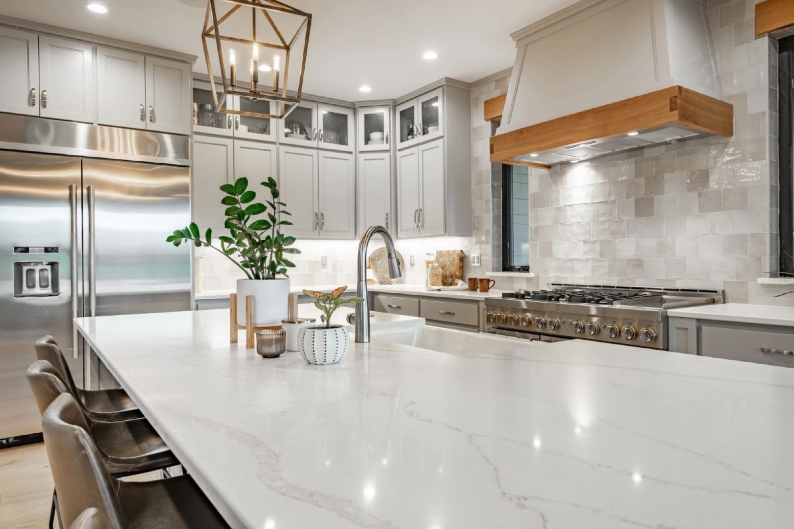 Clean white kitchen with a marble island